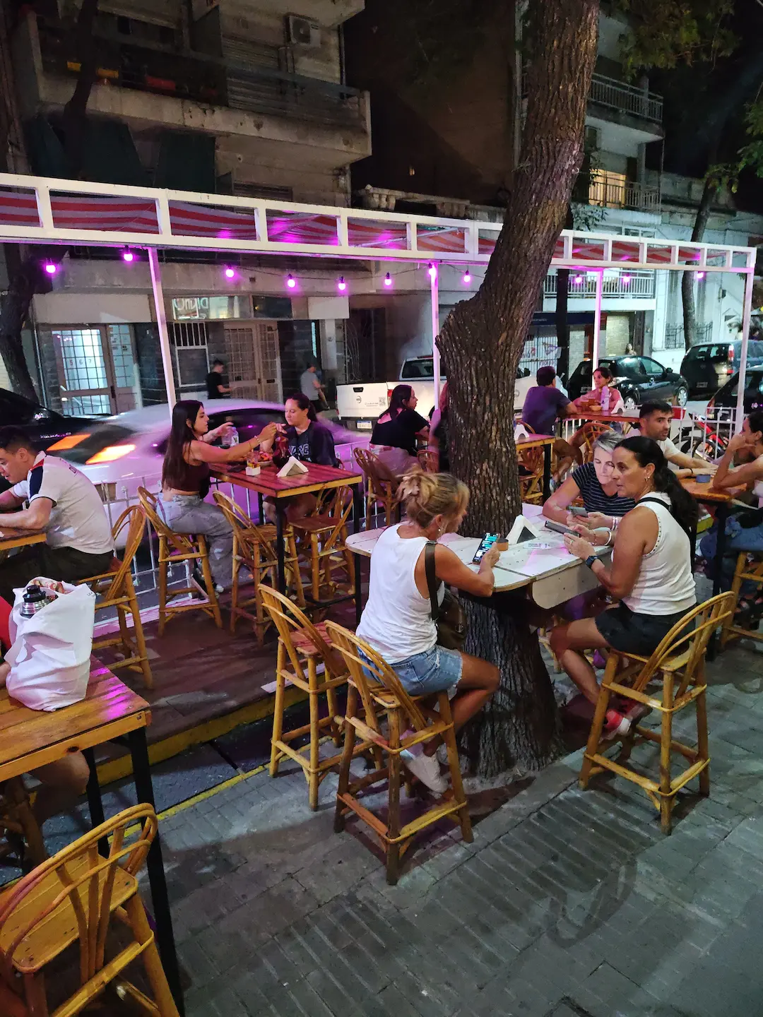 Deck de madera al aire libre con mesas y guirnaldas de luces en Barrio Martín