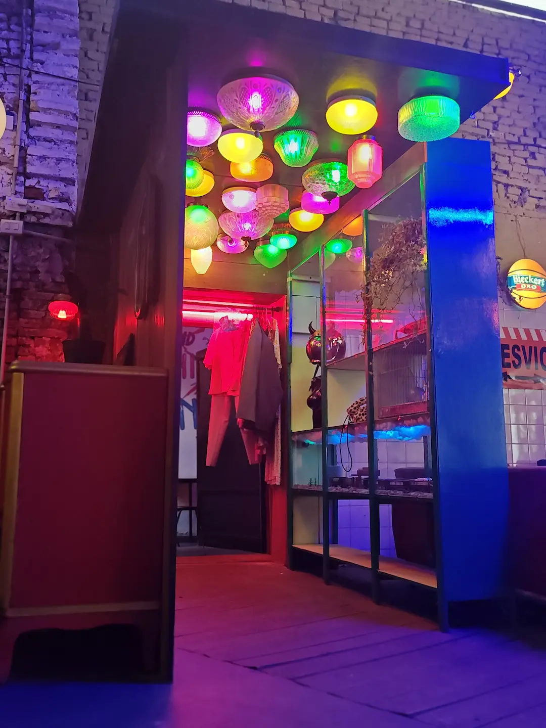 Detalle de iluminación temática con esferas de colores en el techo del bar