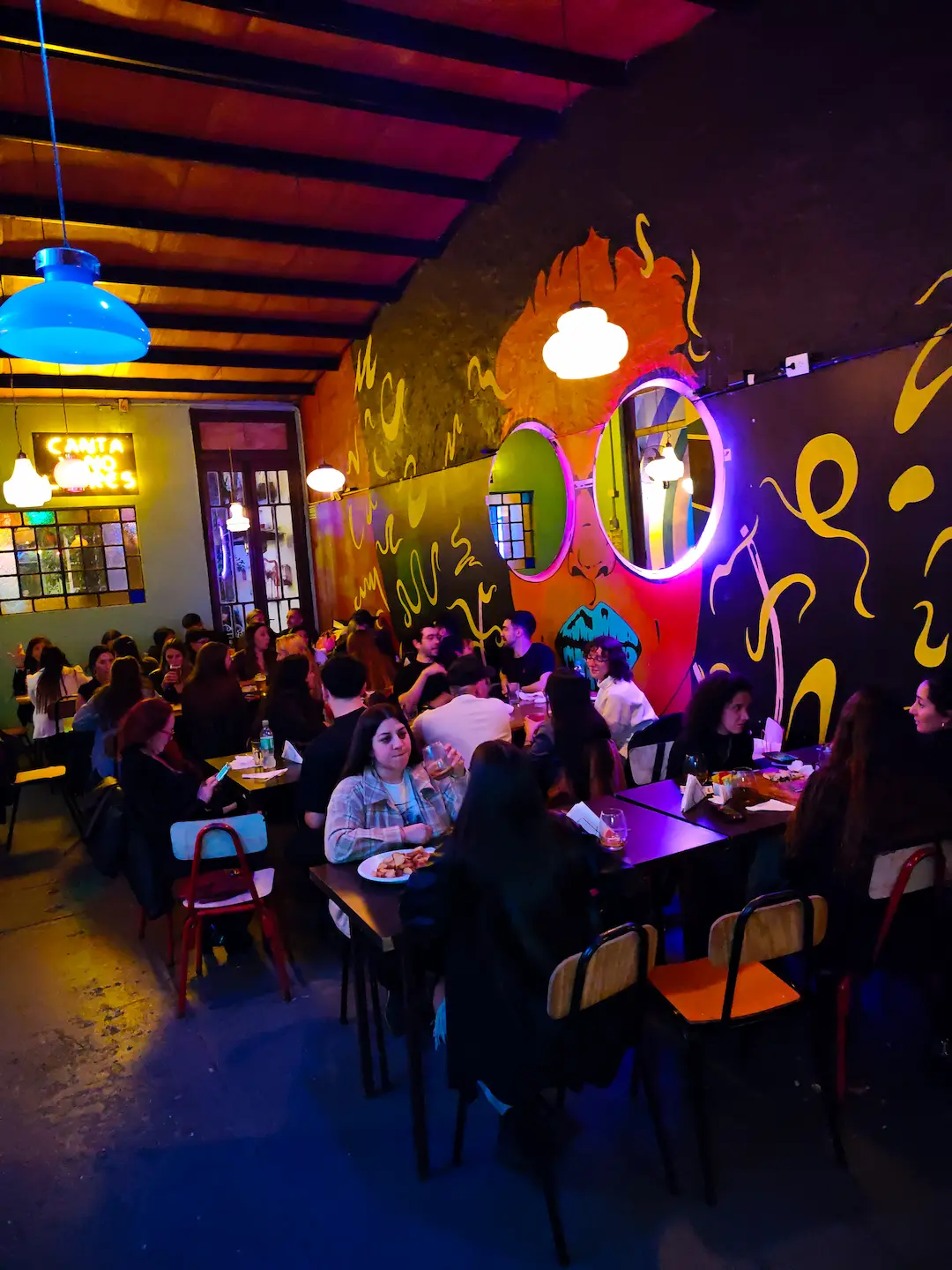 Salón concurrido de noche con gente compartiendo tragos en Digno Bar