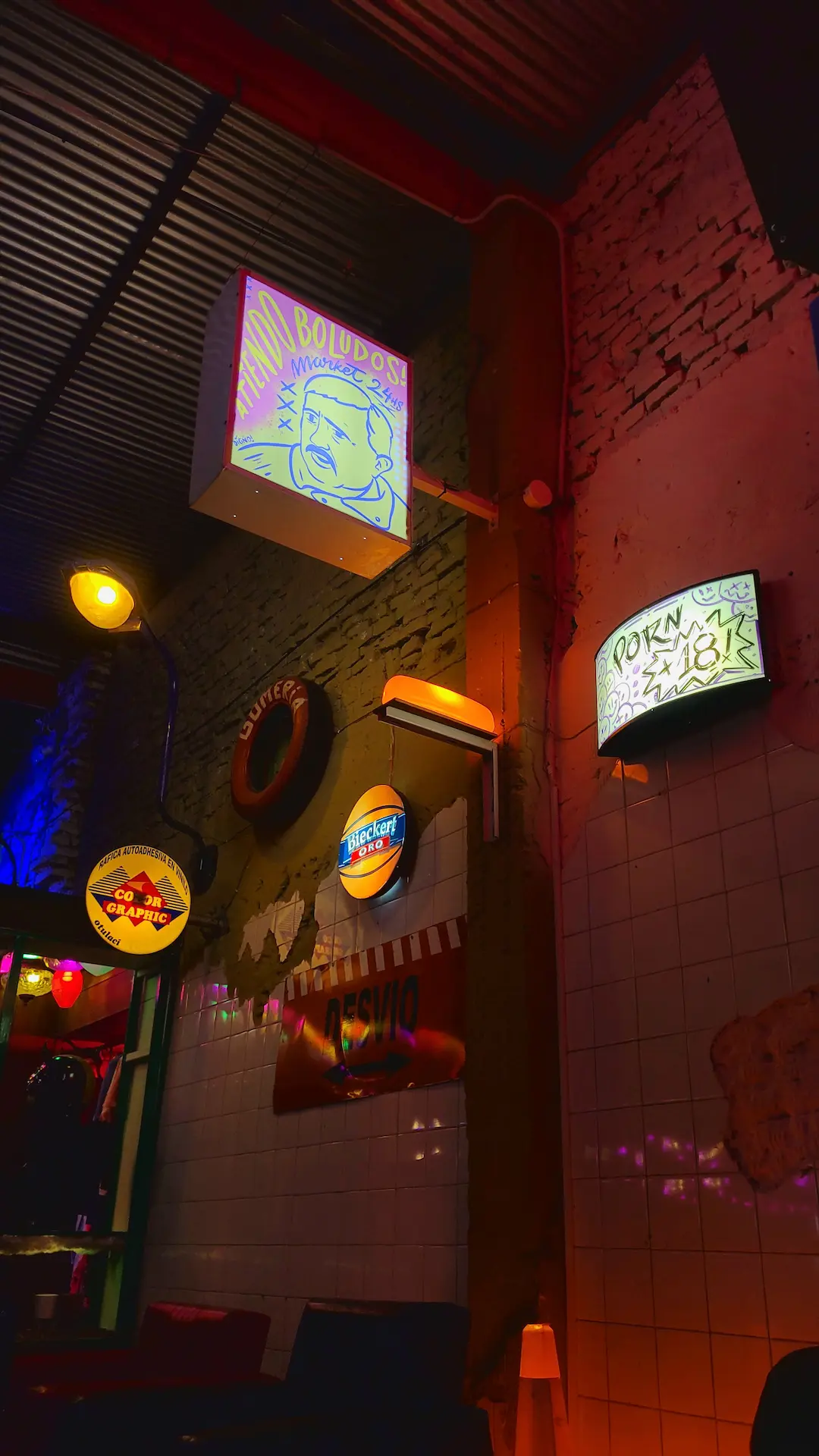 Rincón ambientado con cuadros vintage y luces cálidas de pared